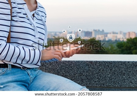 Woman puts up protection on the phone against the background of the cityscape.