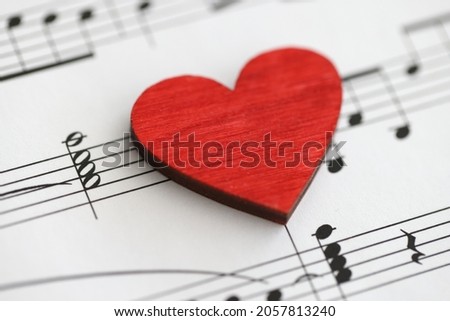 Small red wooden heart with musical notes closeup