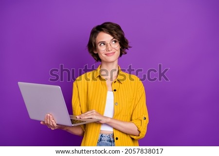 Portrait of attractive dreamy minded cheery girl holding using laptop startup isolated over bright violet purple color background