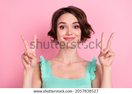 Portrait of attractive funny cheerful girl showing double v-sign isolated over pink pastel color background