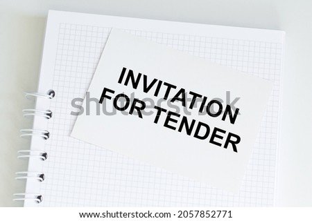 Notepad with a card with text INVITATION FOR TENDER.