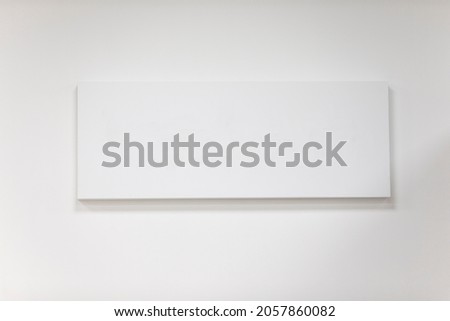 Empty rectangular picture frame on a gray wall.