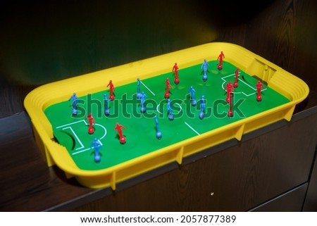 Top view table soccer with red blue players and a ball. Foosball table. Top view of foosball table . Mini table football foosball soccer with players and ball.