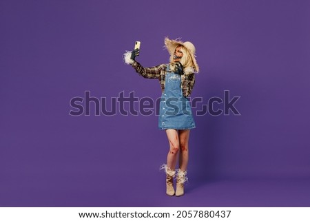 Full body young woman 20s with Halloween makeup mask in straw hat scarecrow costume do selfie shot mobile cell phone say arrr isolated on plain dark purple background studio Celebration party concept