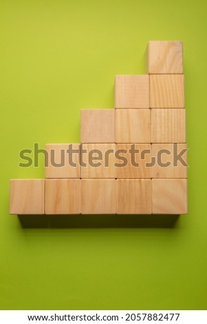 Wooden cubes in the form of graph on pistachio green cokor background