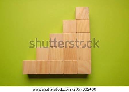Wooden cubes in the form of graph on pistachio green cokor background