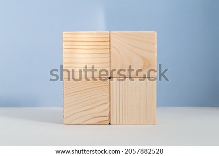 Empty wooden cubes against light blue background, showcase template