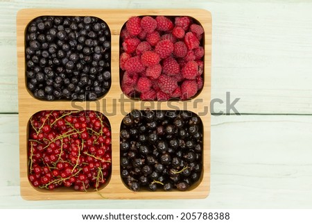 bright, juicy, summer berries lying on wooden surface