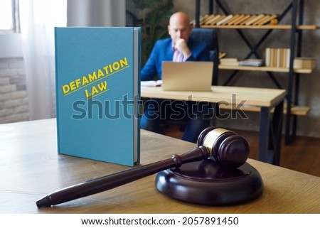 Attorney holds DEFAMATION LAW book. Under common law, to constitute defamation, a claim must generally be false
