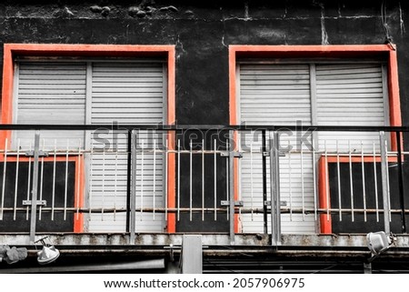 Square geometric shaped windows on black stone facade in Spain