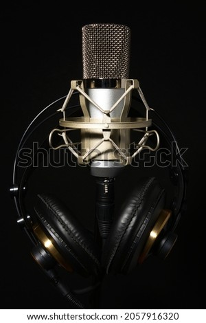 Microphone in Shock Mount with Headphones, Isolated on Black