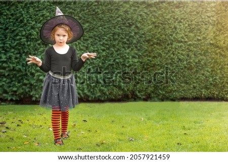 Little girl in a witch costume outside for Halloween