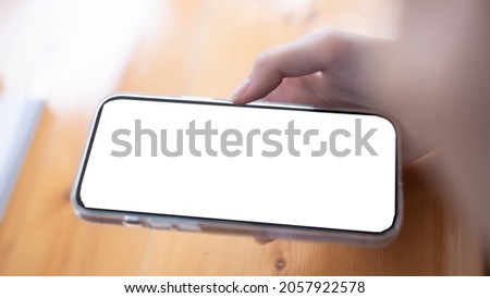 Closeup executive business woman using smartphone at her working desk in office, smartphone blank screen mockup.