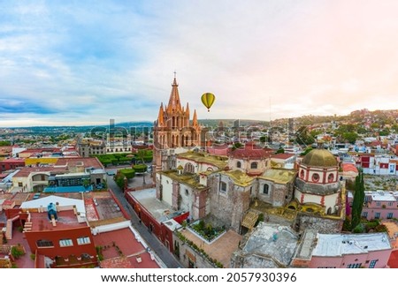 Air tour over the beautiful Parroquia de San Miguel Arcángel surrounded by beautiful colorful houses in the magical town of San Miguel de Allende Royalty-Free Stock Photo #2057930396