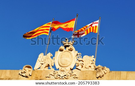 Spanish and Catalan flag against blue sky 