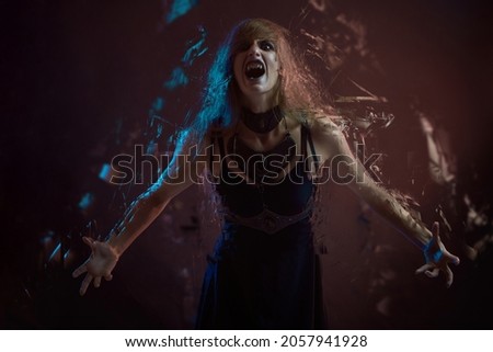 Screaming frustrated witch or vampire girl dispersing and disintegrating into particles, agonizing and torturing expression