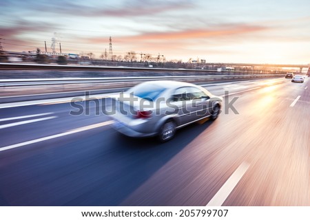 Car driving on freeway at sunset, motion blur Royalty-Free Stock Photo #205799707
