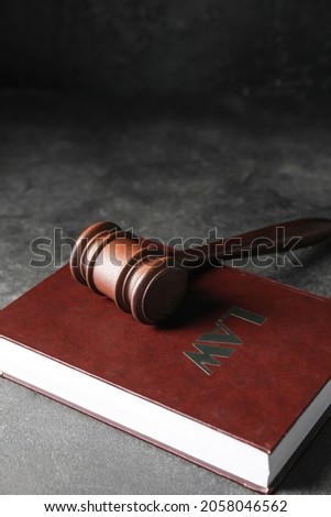 Judge's gavel and law book on dark background