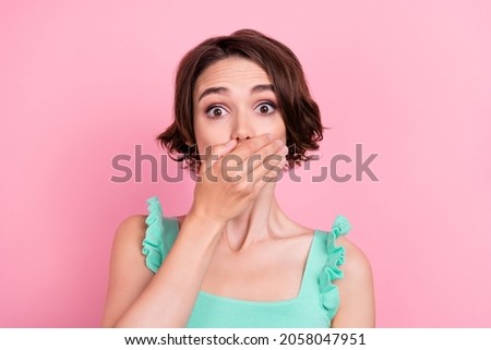 Photo of pretty shocked young woman dressed turquoise tank-top arm cover lips isolated pink color background