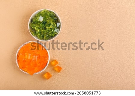 Plates with tasty jelly cubes on color background