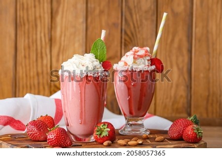Glasses of tasty strawberry milkshake on table Royalty-Free Stock Photo #2058057365