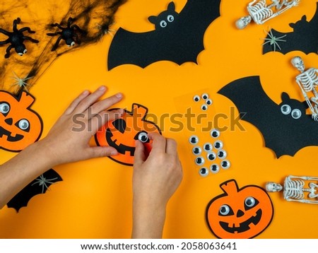 Children's hands make a pumpkin with their own hands, preparing for Halloween.