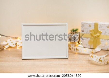Portrait white picture frame mockup with christmas gifts, boken lights. High quality photo