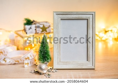 Portrait white picture frame mockup with christmas gifts, boken lights. High quality photo