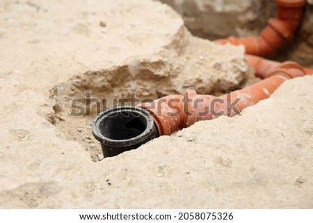 Installation of PVC sewer pipes and water drain in a bathroom. Close up detail of home renovation and repair. Royalty-Free Stock Photo #2058075326