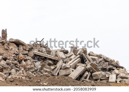 The wreckage of a destroyed building isolated on a white background. Pieces of concrete walls, steel reinforcement and fragments of cement. Building demolition or collapse concept. Copy space Royalty-Free Stock Photo #2058083909