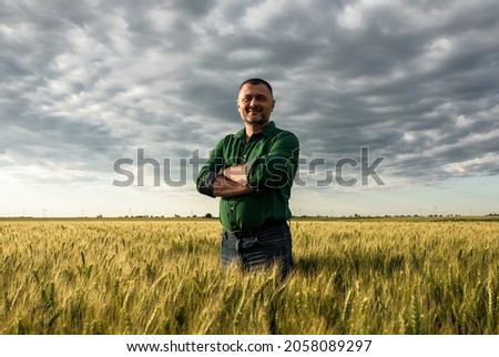 Portrait of farmer standing in wheat field. Royalty-Free Stock Photo #2058089297