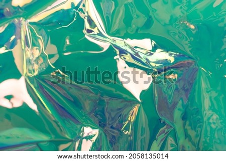 Turquoise holographic background. Wrinkled foil material. Soft focus fluid waves.