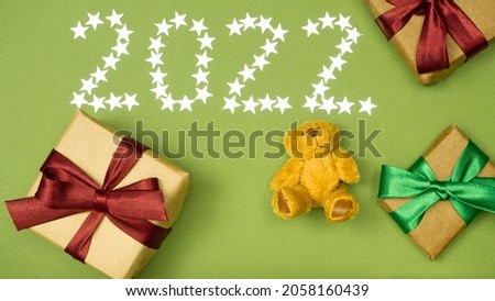 Christmas background .little bear on a green background .gifts .new year numbers