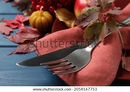 Festive table setting with autumn decor on blue wooden background, closeup