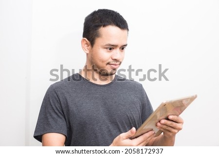 Business asian man use ipad tablet computer standing on white background