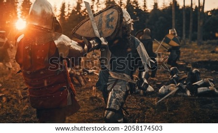 Medieval Knight Walking on Battlefield amidst Dead Enemies. Last Surviving Crusader, Soldier, Warrior after Battle. Destruction of War, Invasion, Crusade. Dramatic, Cinematic Historic Reenactment Royalty-Free Stock Photo #2058174503