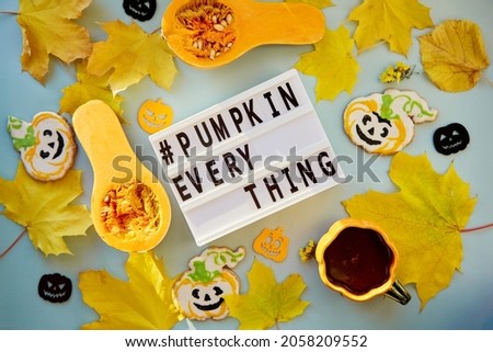 Text pumpkin everything among autumn decorations and food. Orange teacup with homemade cookies, fresh pumpkins, yellow leaves and decorations of pumpkins. High quality photo