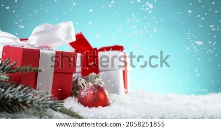 Christmas gits with decorations on snow, free space for text. Celebration and holidays background.