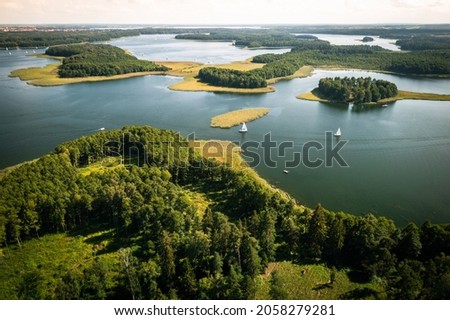 Masuria. Aerial view of green islands and clouds at summer sunny day. Masurian Lake District in Poland.  Royalty-Free Stock Photo #2058279281
