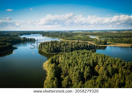 Masuria. Aerial view of green islands and clouds at summer sunny day. Masurian Lake District in Poland.  Royalty-Free Stock Photo #2058279320