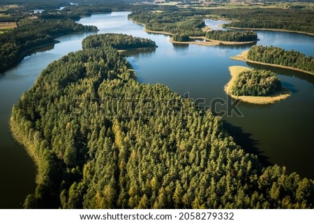 Masuria. Aerial view of green islands and clouds at summer sunny day. Masurian Lake District in Poland.  Royalty-Free Stock Photo #2058279332