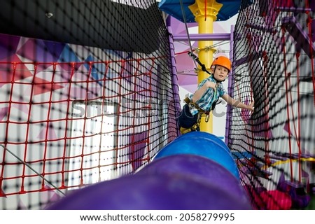 A boy climbs on the ropes, zip line