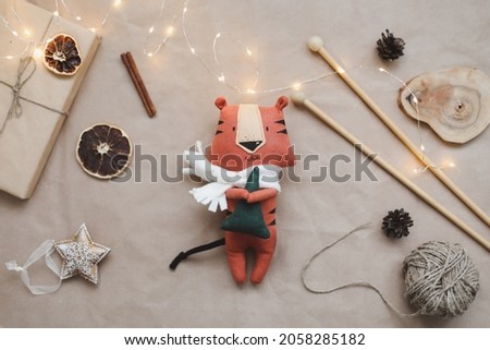 Christmas composition with a tiger toy, symbol of new 2022, a gift, fir tree branches and decorations. Christmas, winter, new year concept. Flat lay, top view