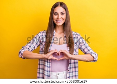 Photo of young woman happy positive smile show fingers heart symbol love isolated over yellow color background
