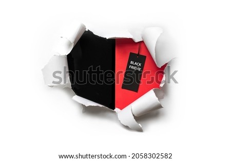 Torn white paper on a red and black background with a Black Friday price tag. Copy space for text