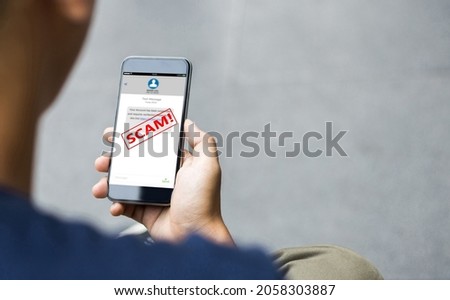 Text message SMS scam or phishing concept. Man hands using smart phone Royalty-Free Stock Photo #2058303887