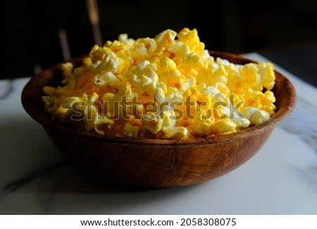 Homemade movie theater popcorn with butter in wooden bowl for movie night