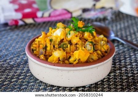 Typical ecuadorian dish "Mote Pillo" made with andean giant white corn, egg, onion, achiote and herbs, serve on a rustic tray; folk plate from Cuenca, Ecuador. Blurred background. Mountain region. Royalty-Free Stock Photo #2058310244