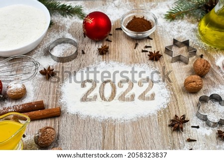 2022 year. Products for baking homemade Christmas cookies on a wooden background with the inscription 2022. The concept of the holiday, celebration and cooking.