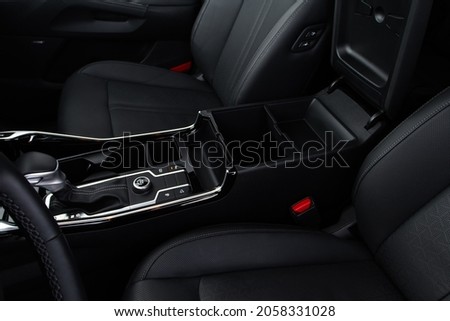 Car armrest opened. Opened armrest in the car for driver. Royalty-Free Stock Photo #2058331028